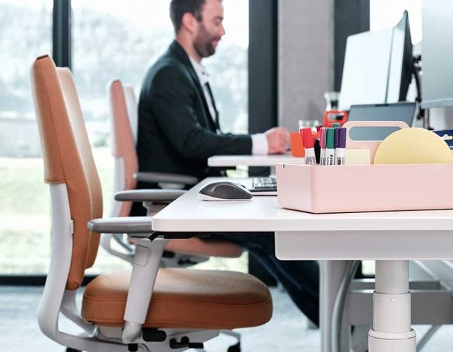 Mitarbeiter von Streit Service & Solution sitzt am Arbeitsplatz und arbeitet am Computer. Neben ihm ist ein leerer Arbeitsplatz.