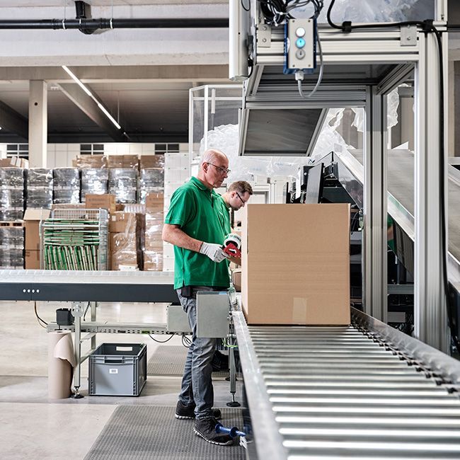Mann macht Paket versandfertig