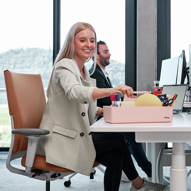 Frau greift zur Toolbox am Arbeitsplatz