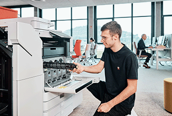 Mitarbeiter wechselt Toner an Drucksystem