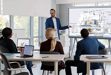 Mitarbeiter folgen einer Präsentation am Whiteboard
