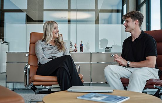 Frau und Mann unterhalten sich in Lounge im Büro