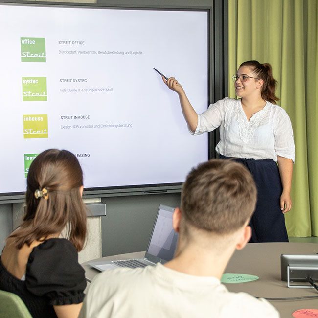 Auszubildende von Streit Service & Solution präsentiert etwas auf einem Bildschirm