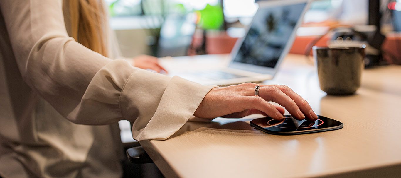 Person bucht sich einen Arbeitsplatz per Touchpad am Schreibtisch
