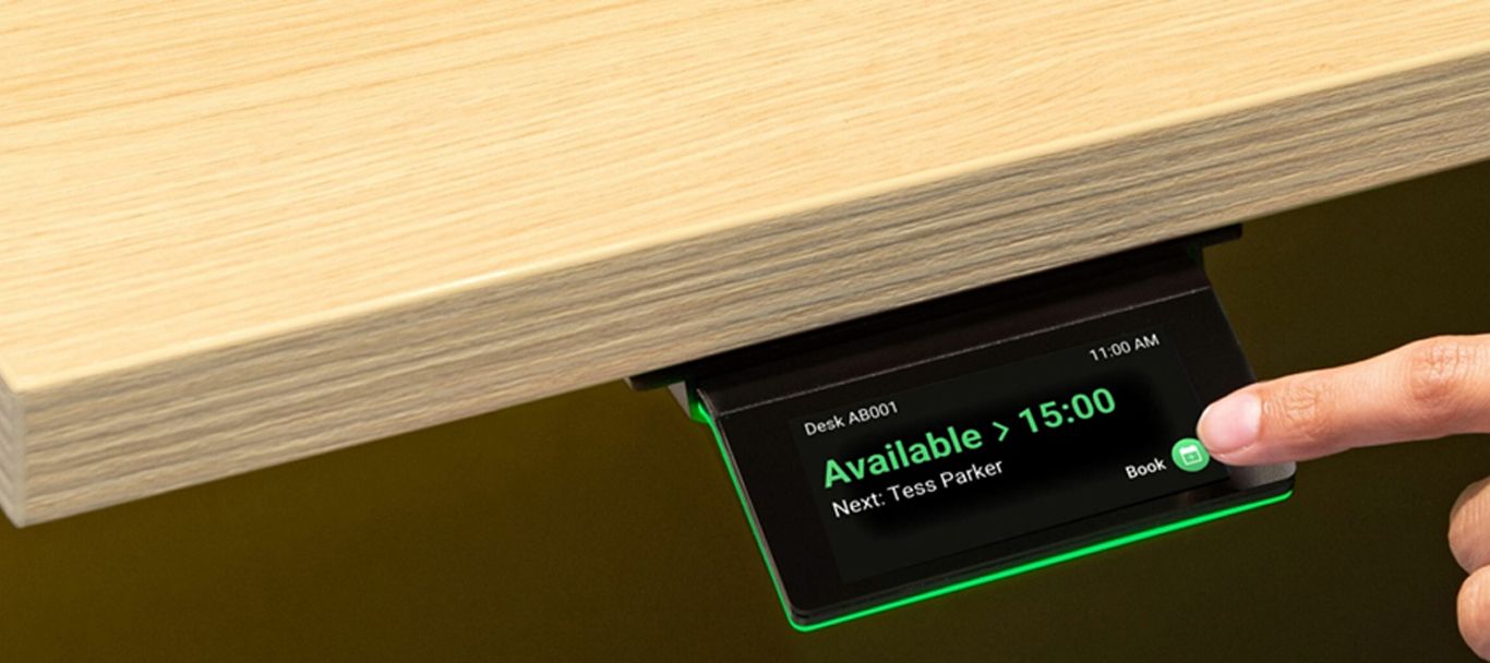 Person bucht sich einen Arbeitsplatz per Touchpad am Schreibtisch