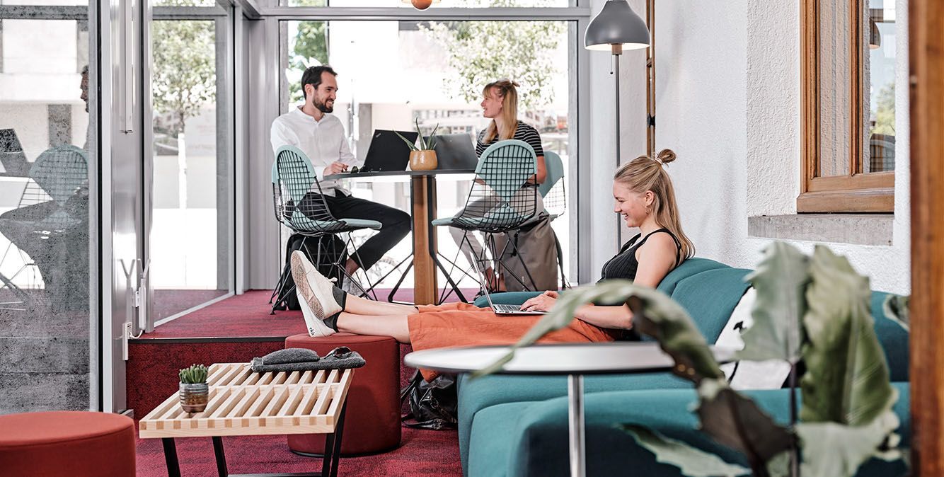 Personen sitzen in einem Co-Working Büro in Freiburg und arbeiten