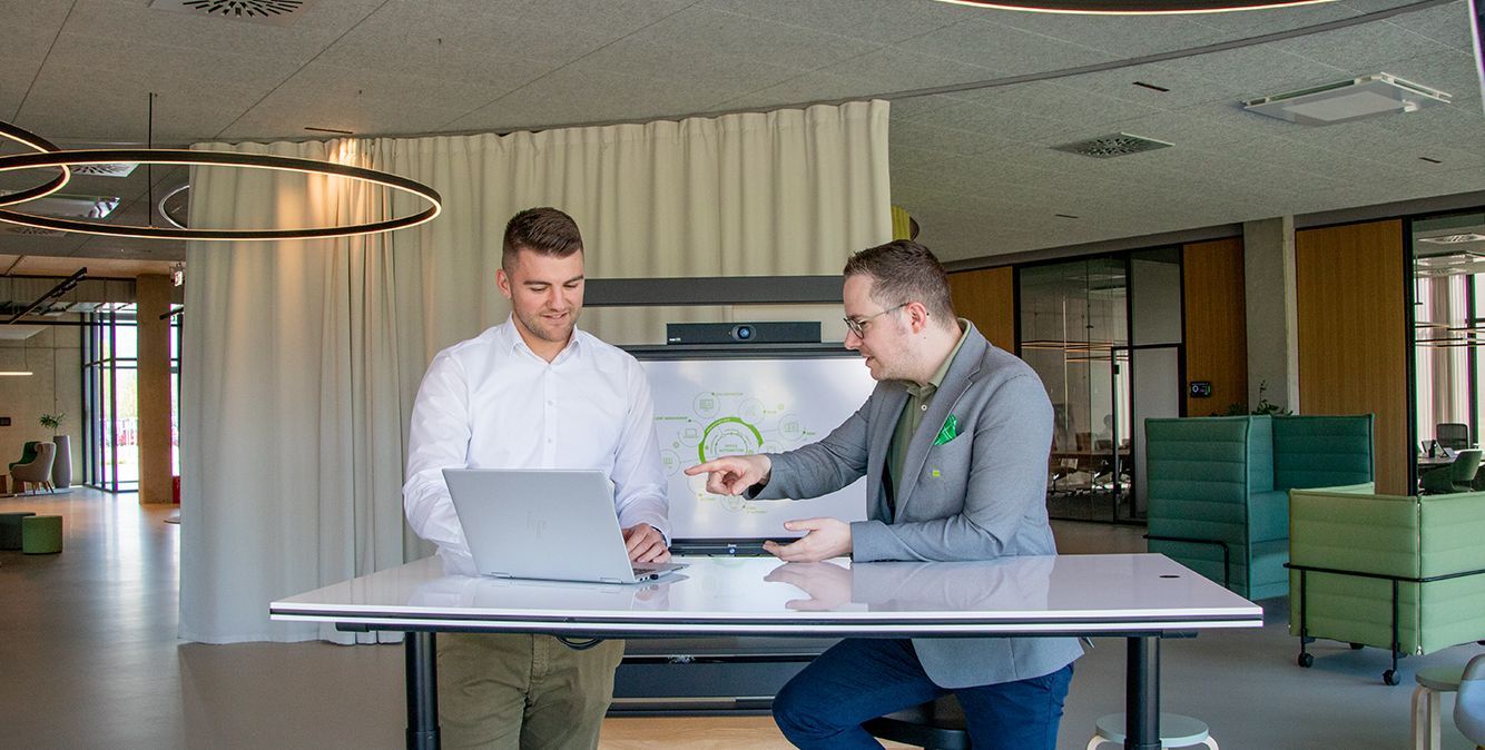 Mitarbeiter von Streit Service & Solution sitzen zusammen an einem Tisch und arbeiten am Laptop