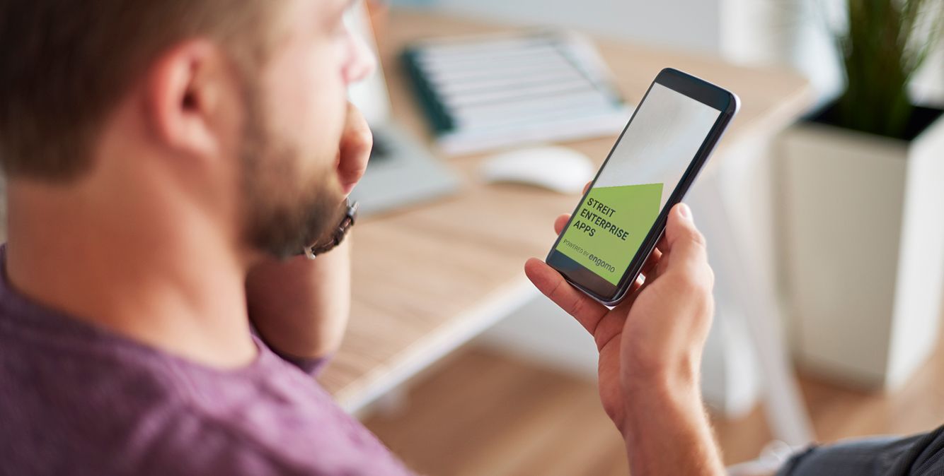 Mann schaut auf sein Handydisplay auf dem die STREIT Enterprise App zu sehen ist