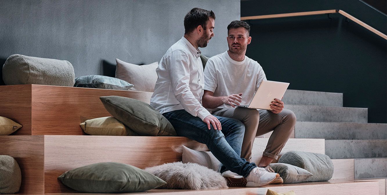 Mitarbeiter von Streit Service & Solution sitzen zusammen und arbeiten an einem Laptop