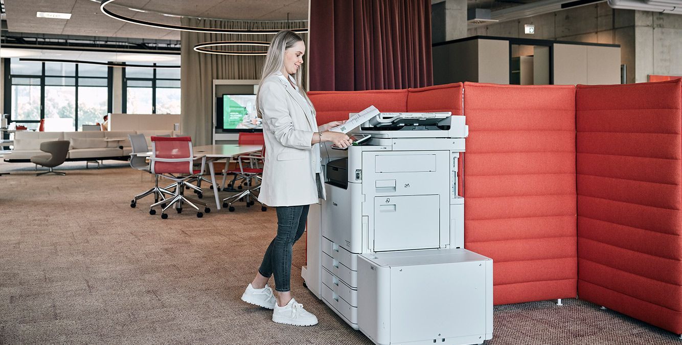 Mitarbeiterin von Streit Service & Solution steht am Printer in der Arbeitswelt in Gengenbach