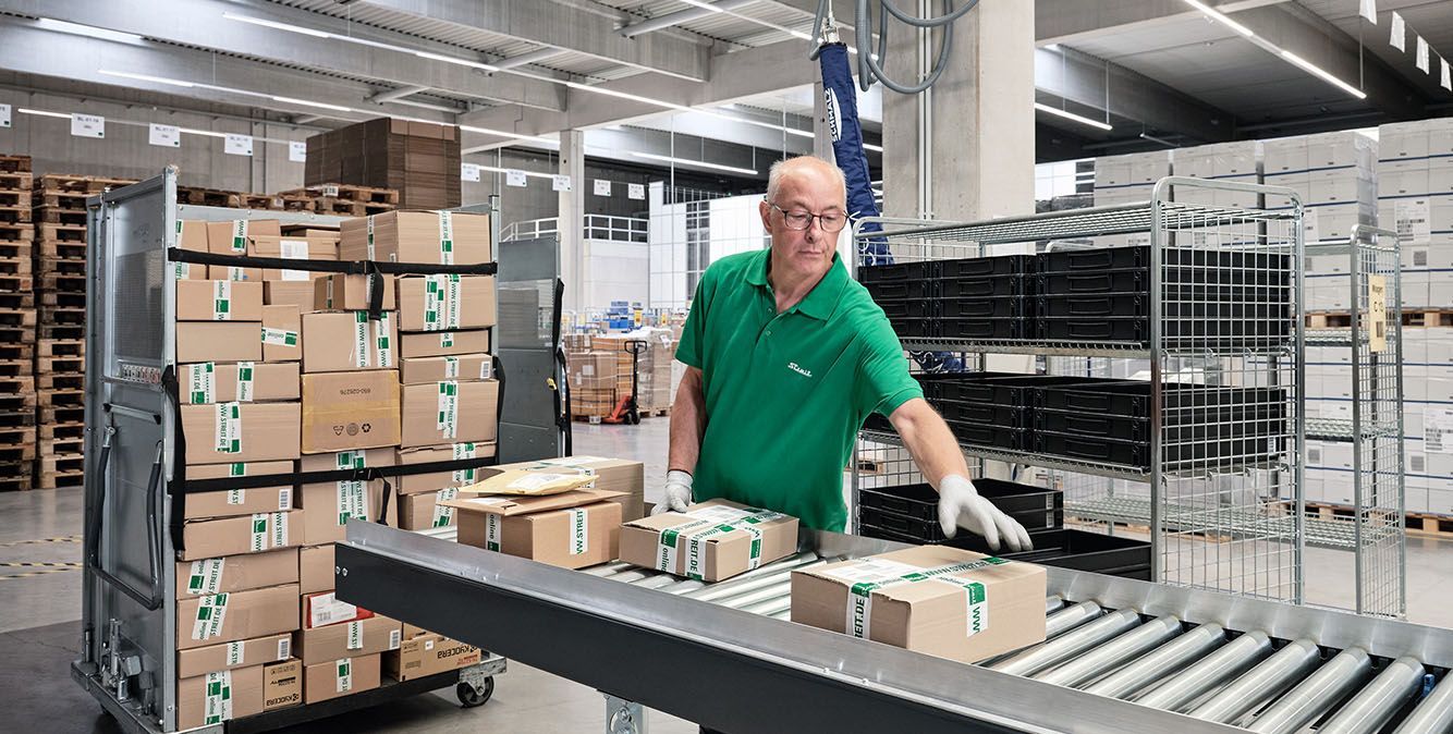 Mitarbeiter von Streit Service & Solution verladet Pakete im Logistikzentrum in Gengenbach