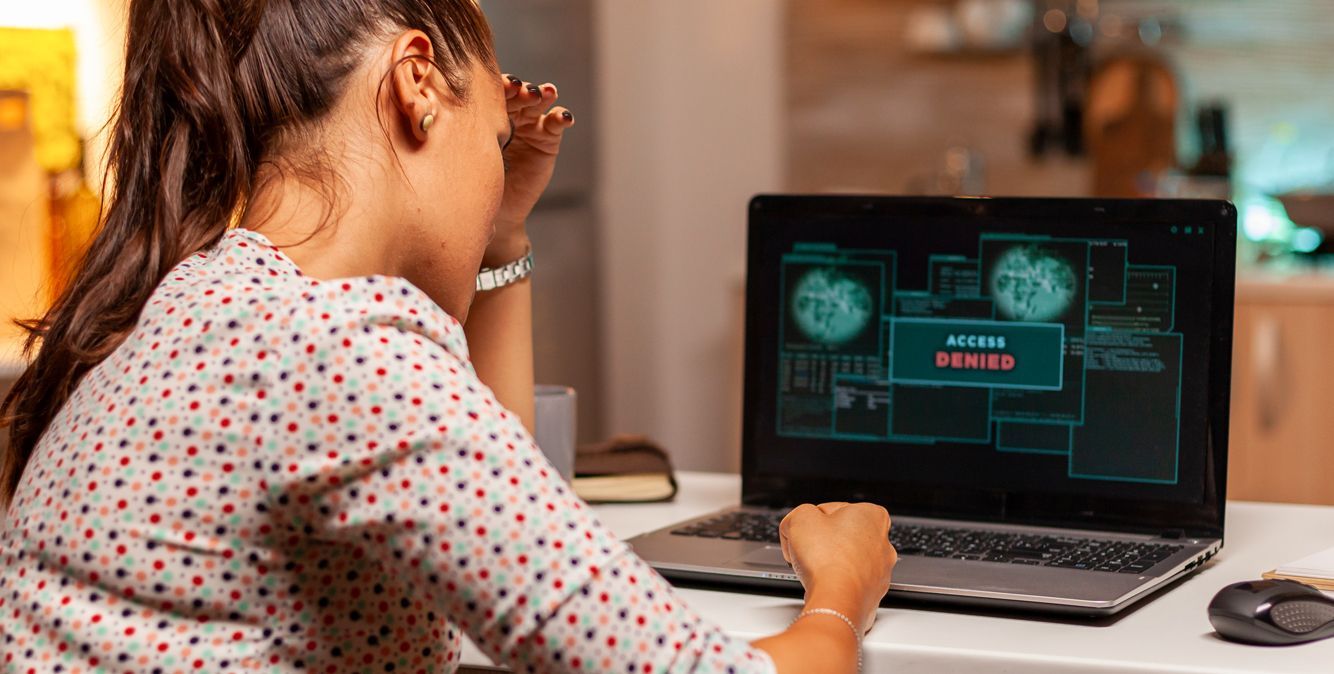 Frau sitzt vor dem Laptop und sieht eine Fehlermeldung