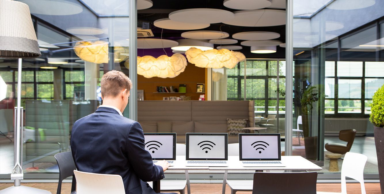 Mitarbeiter von Streit Service & Solution arbeitet an einem Tisch auf dem mehrere Laptops stehen