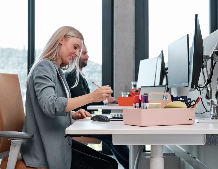 Mitarbeiter von Streit Service & Solution arbeiten am Schreibtisch und benutzen Bürobedarfsartikel