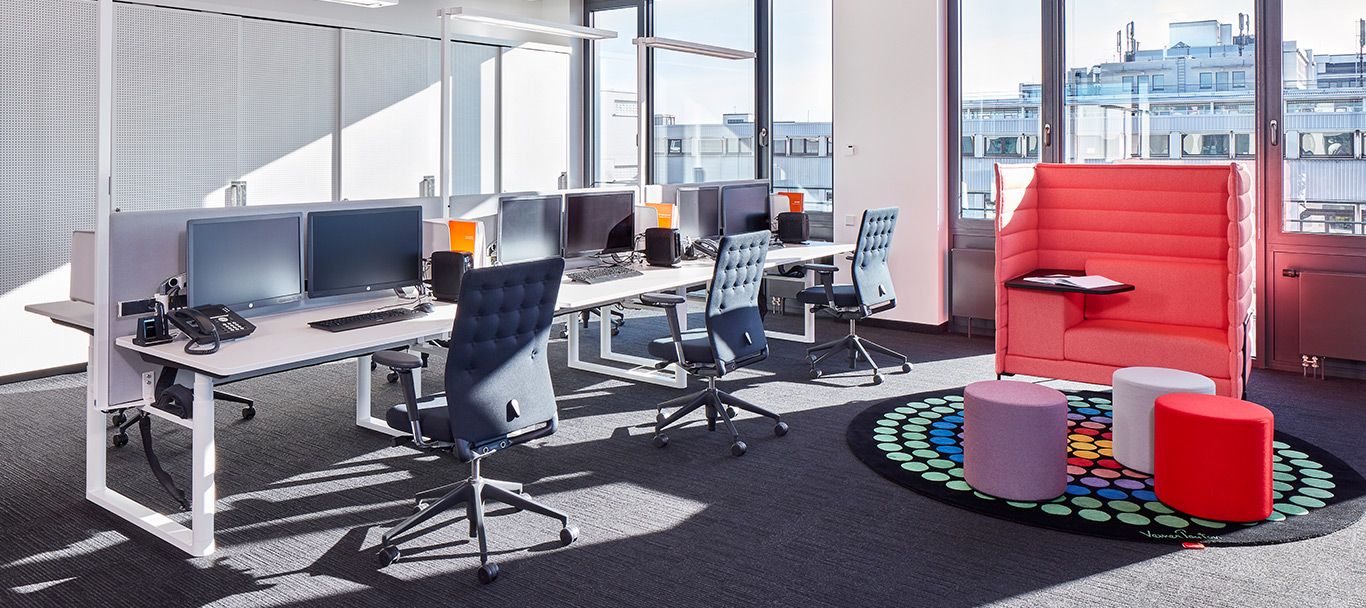 Ergonomischer Arbeitsplatz mit Schreibtischen und Drehstühlen