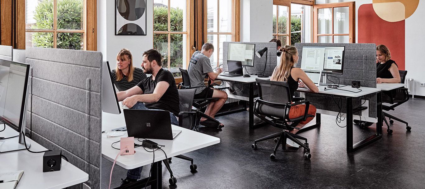 Ergonomischer Arbeitsplatz mit Schreibtischen und Drehstühlen