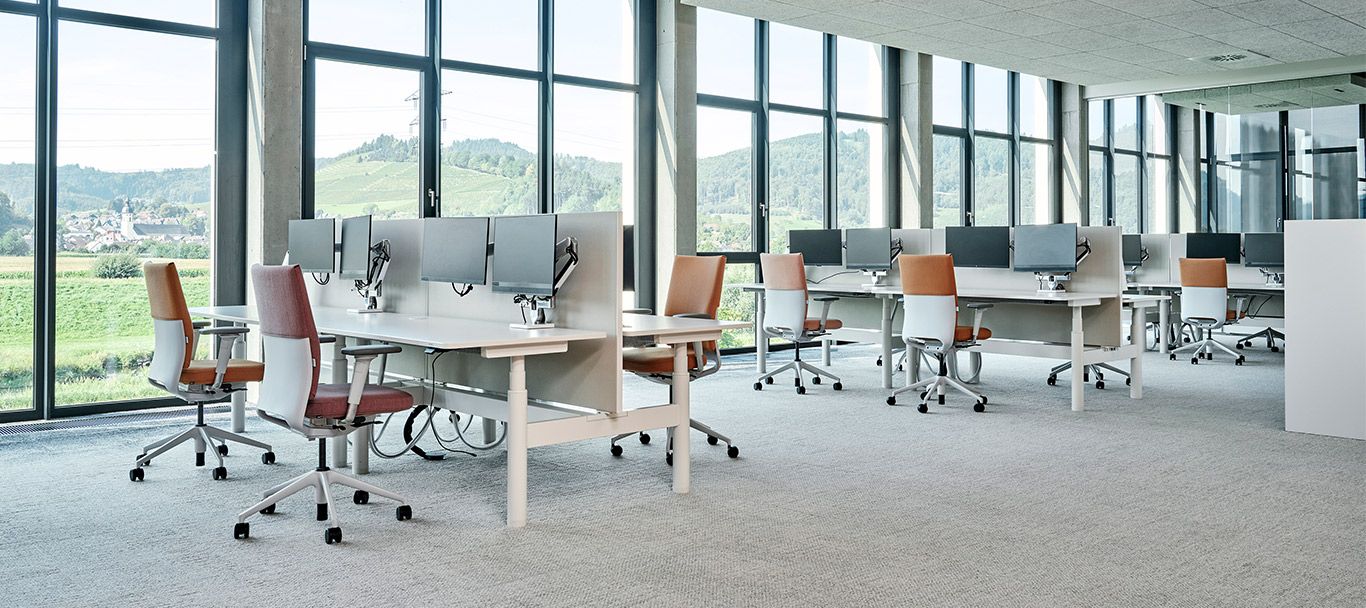 Ergonomischer Arbeitsplatz mit Schreibtischen und Drehstühlen