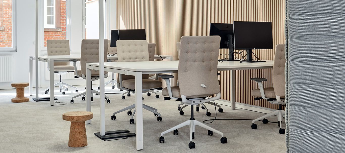 Ergonomischer Arbeitsplatz mit Schreibtischen und Drehstühlen