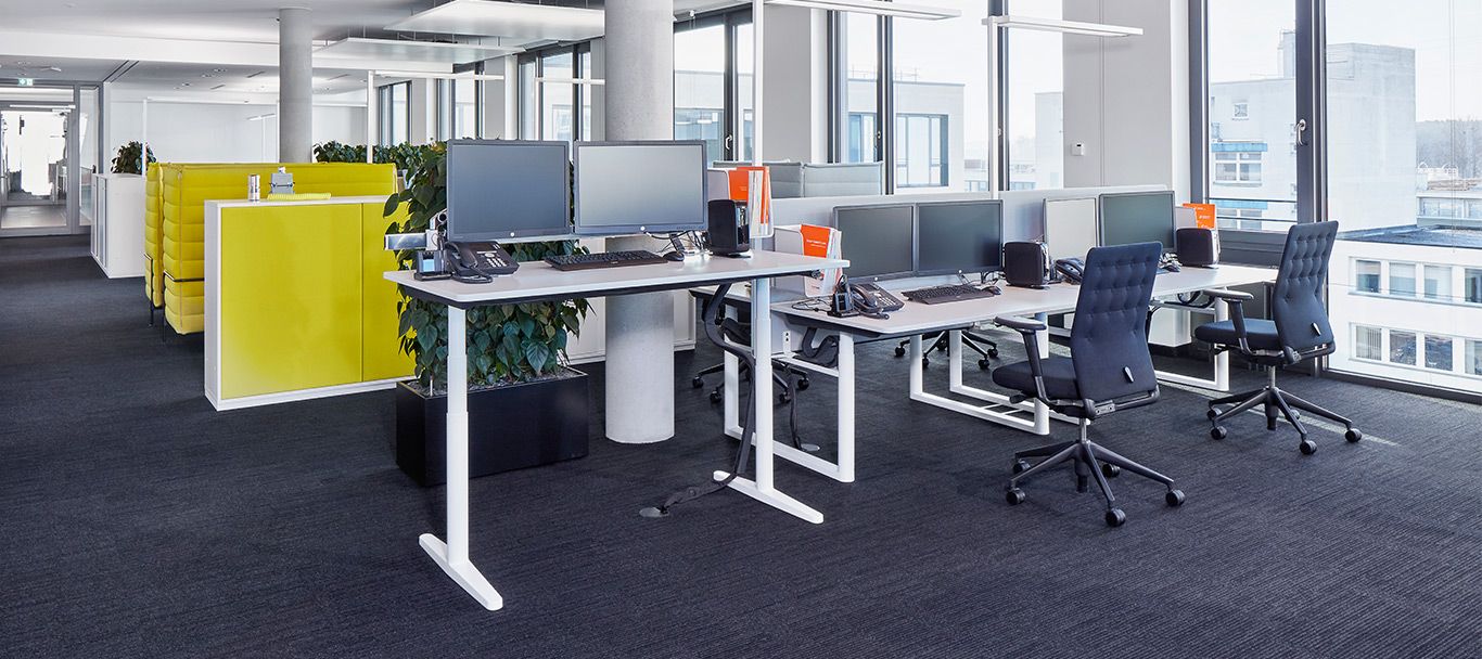 Ergonomischer Arbeitsplatz mit Schreibtischen und Drehstühlen