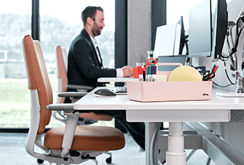 Mitarbeiter von Streit Service & Solution sitzt am Arbeitsplatz und arbeitet am Computer. Neben ihm ist ein leerer Arbeitsplatz.
