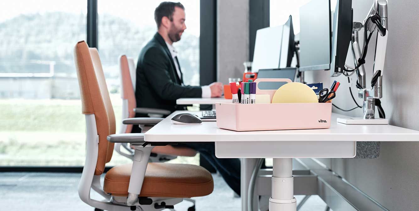 Mitarbeiter von Streit Service & Solution sitzt am Arbeitsplatz und arbeitet am Computer. Neben ihm ist ein leerer Arbeitsplatz.