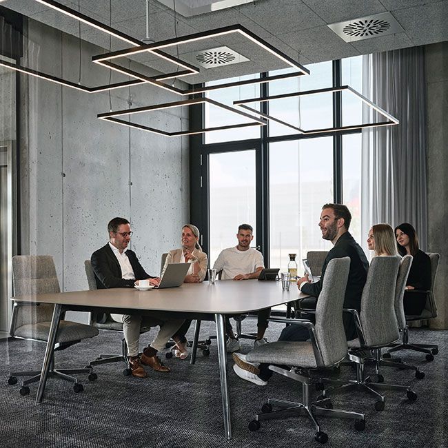 Mitarbeiter von Streit Service & Solution sitzen in einem Besprechungsraum an einem Tisch und sprechen miteinander