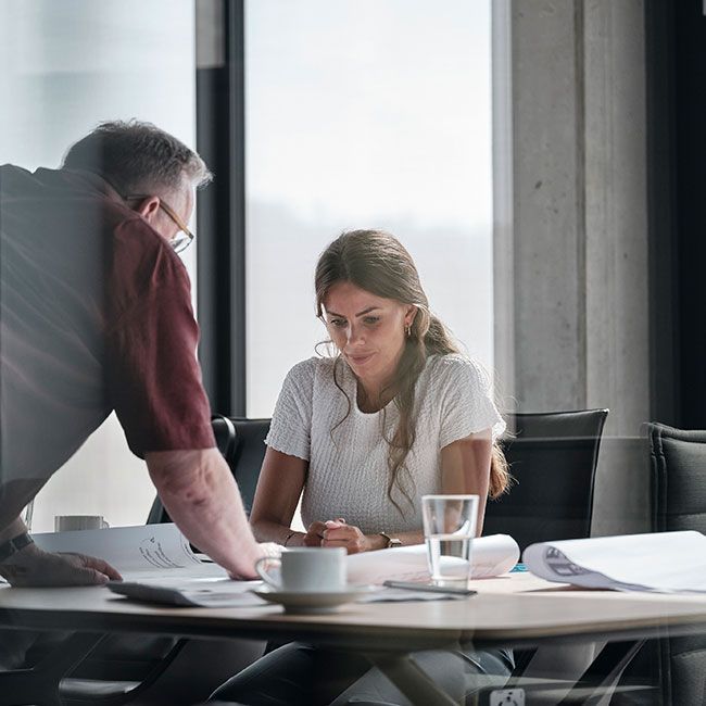 Mitarbeiter von Streit Service & Solution schauen sich einen Büroplan auf einem Tisch an