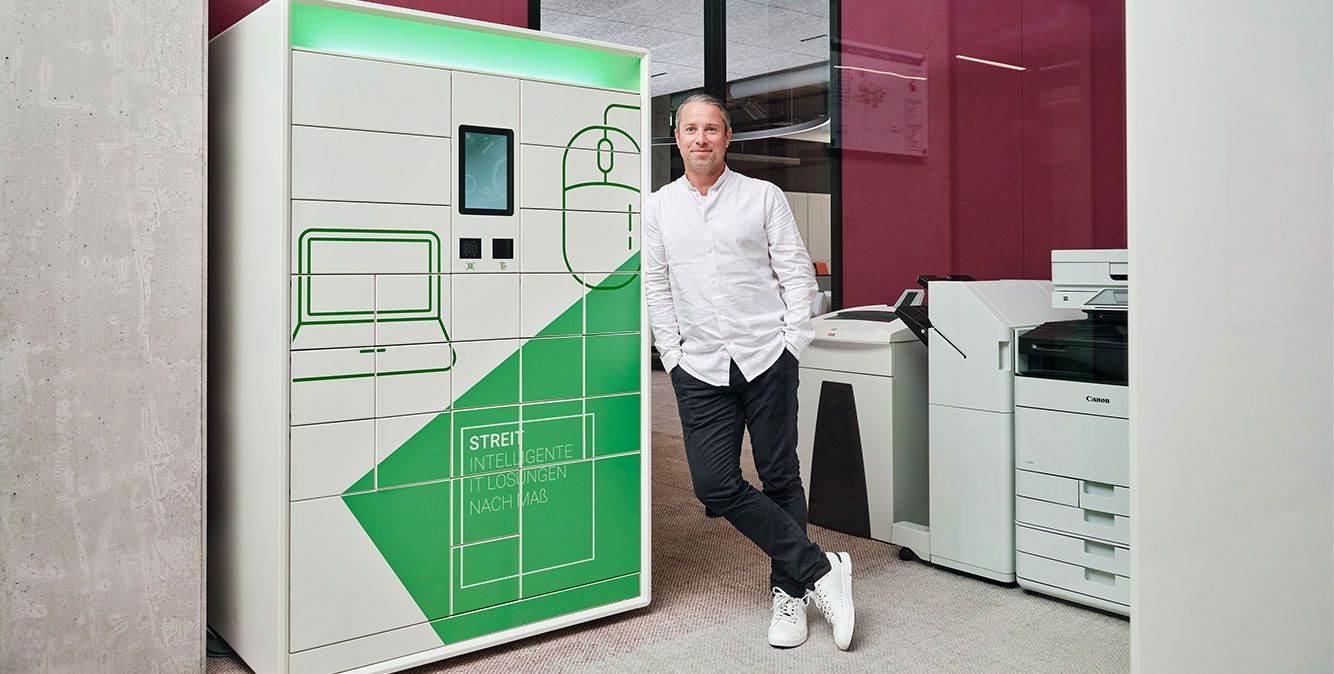 Mitarbeiter von Streit Service & Solution steht neben dem IT-Automaten Cora