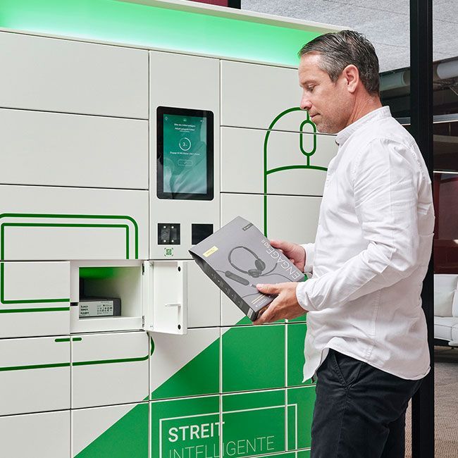 Mitarbeiter von Streit Service & Solution holt ein Headset aus dem Cora IT-Automaten