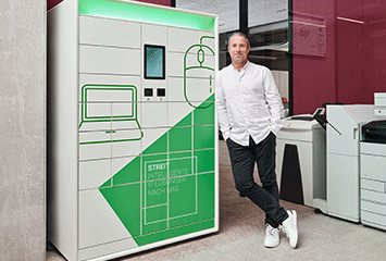 Mitarbeiter von Streit Service & Solution steht neben dem IT-Automaten Cora