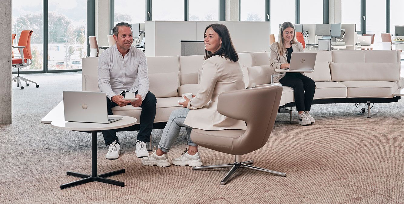 Mitarbeiter von Streit Service & Solution sitzen auf einem Sofa in der Arbeitswelt in Gengenbach und arbeiten
