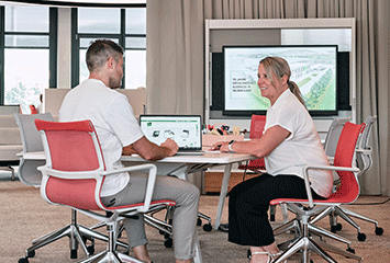 Mitarbeiter von Streit Service & Solution arbeiten zusammen an einem Laptop und unterhalten sich 