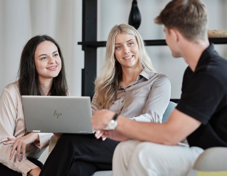 Drei Mitarbeiter von STREIT sitzen zusammen und arbeiten an einem Laptop