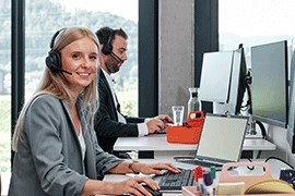 Mitarbeiter von Streit Service & Solution arbeiten am Schreibtisch und Telefonieren per Headset