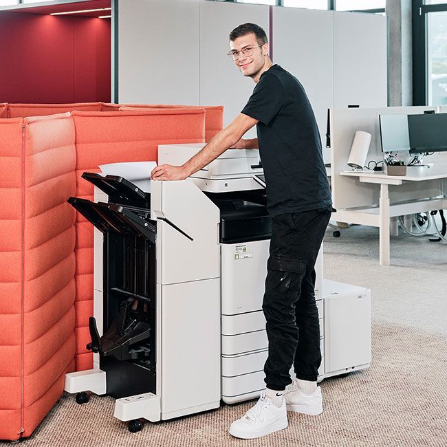 Mitarbeiter von Streit Service & Solution bedient ein Drucksystem