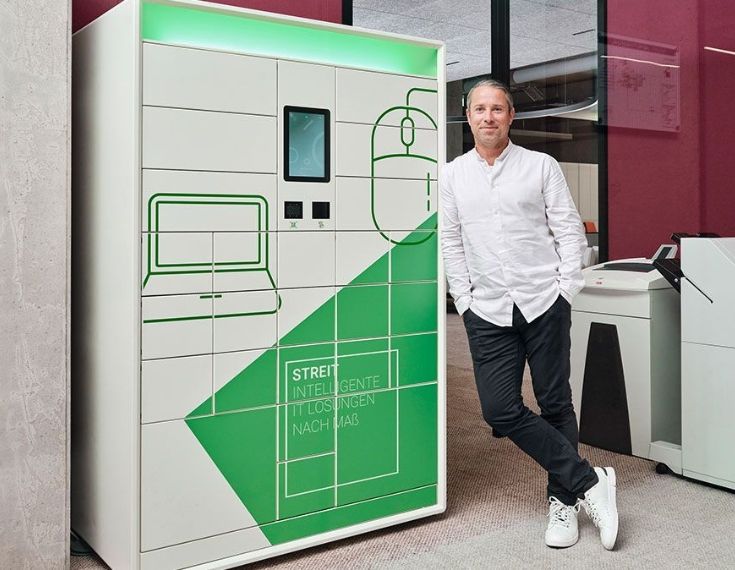 Mitarbeiter von Streit Service & Solution steht neben dem IT-Automaten