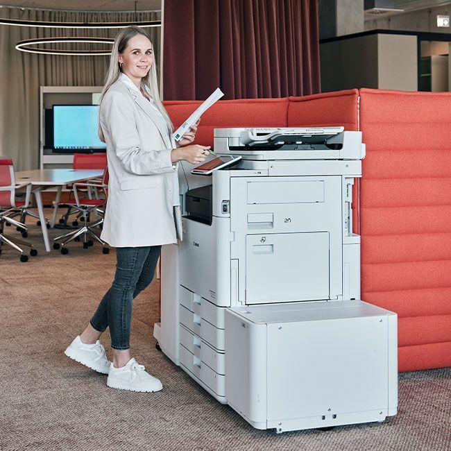 Mitarbeiterin von Streit Service & Solution steht an einem Printer und druckt etwas