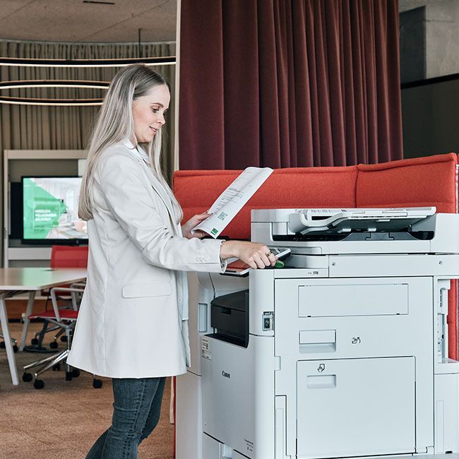 Mitarbeiterin von Streit Service & Solution bedient einen Drucker in der Arbeitswelt in Gengenbach