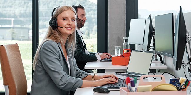 Mitarbeiterin mit Headset am Telefonieren
