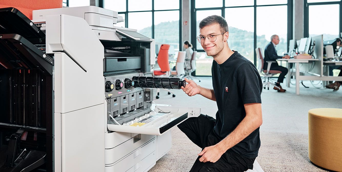 Mitarbeiter von Streit Service & Solution füllt bei einem Drucker Toner nach