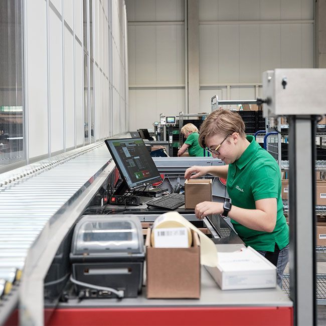 Mitarbeiterin von Streit Service & Solution packt im Logistikzentrum in Gengenbach ein Packet