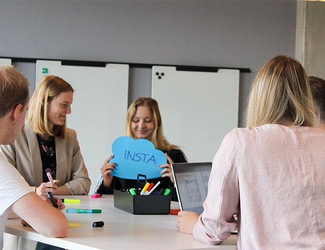 Auszubildende des Unternehmens Streit Service & Solution arbeiten zusammen und nutzen dabei Laptop, Stifte und Papier.