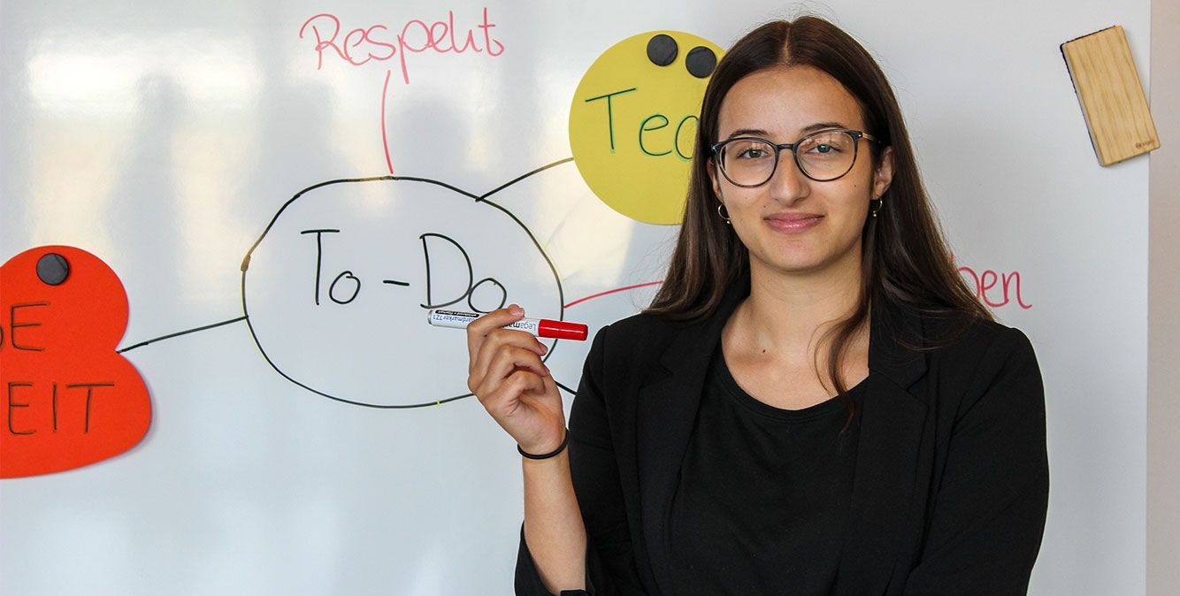 Duale Studentin von Streit Service & Solution steht vor einem Whiteboard