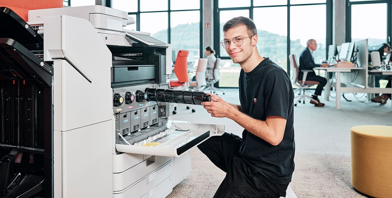 Auszubildender von Streit Service & Solution füllt eine neue Patrone in einen Drucker ein