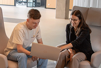 Zwei duale Studenten von Streit Service & Solution arbeiten zusammen an einem Laptop