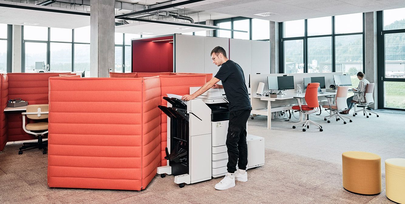 Mitarbeiter von Streit leasing steht an einem Drucker im Büro