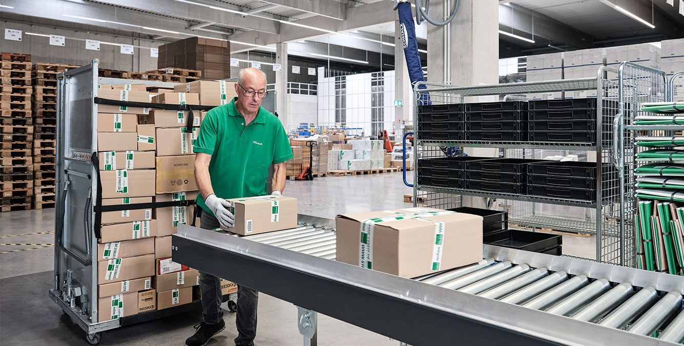 Mitarbeiter von Streit Service & Solution verladet Pakete im Logistikzentrum in Gengenbach