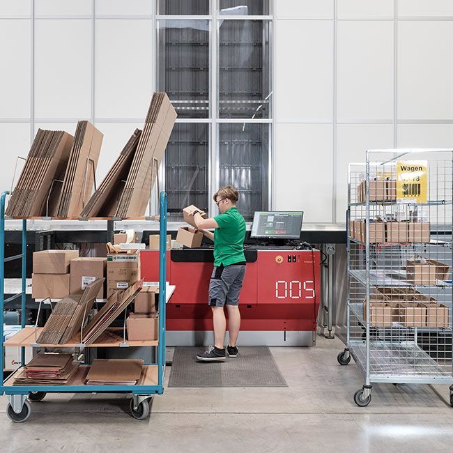 Mitarbeiterin von Streit Service & Solution packt Pakete im Logistikzentrum in Gengenbach