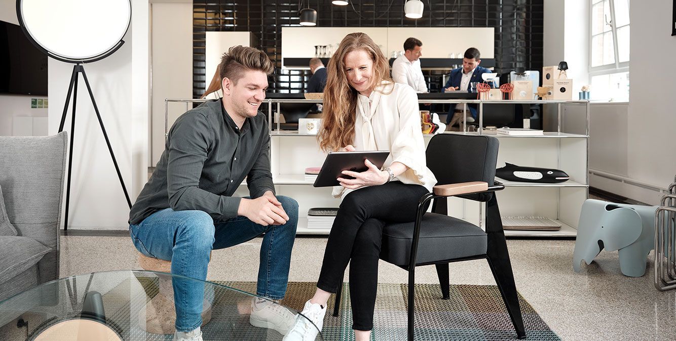Mitarbeiter von Streit Service & Solution sitzen zusammen und arbeiten an einem Tablet