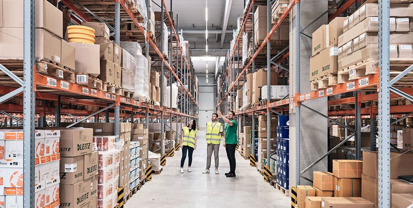 Mitarbeiter von Streit Service & Solution stehen im Hochregallager im Logistikzentrum in Gengenbach
